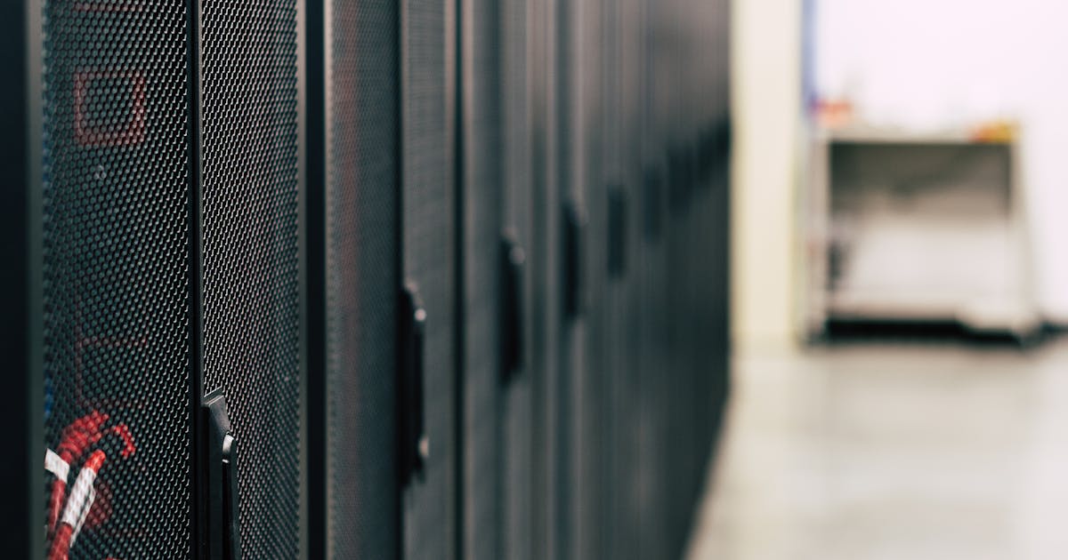 Veri merkezinde sıralı sunucu kabinetlerini gösteren teknik fotoğraf Veri merkezinde sıralı sunucu kabinetlerini gösteren teknik fotoğraf